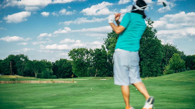 Golfer driving through a swing on the fairway