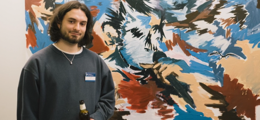 Artist standing next to their work