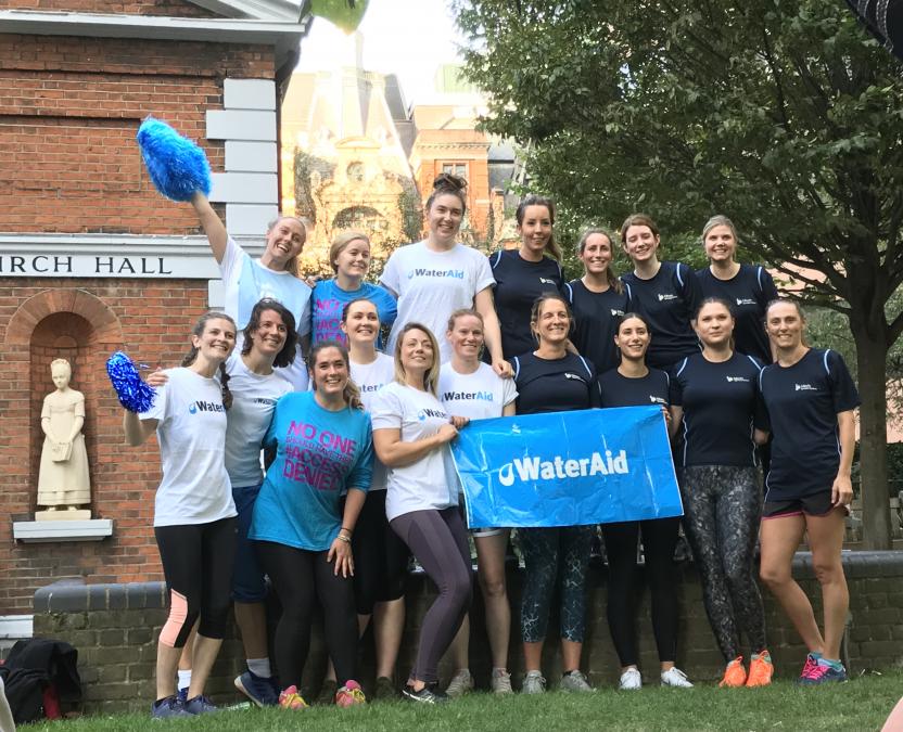 People smiling holding wateraid banner